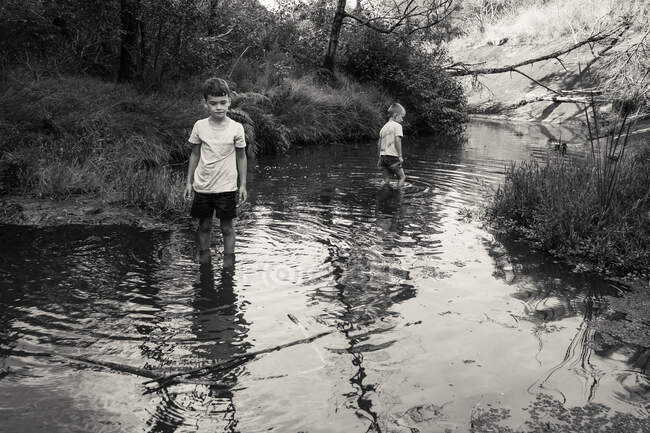 Хлопці блукають річкою — стокове фото