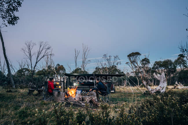 Casal relaxante na fogueira no Parque Nacional Alpino Austrália — Fotografia de Stock