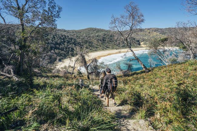 Homens caminhando no caminho para a ensolarada praia oceânica remota Jervis Bay Austrália — Fotografia de Stock
