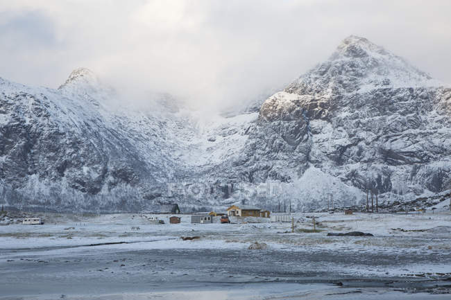 Neve coberto montanhas e cabines remotas Flakstad Lofoten Noruega — Fotografia de Stock