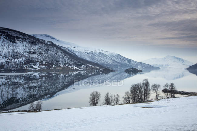 Lago tranquilo e montanhas cobertas de neve Noruega — Fotografia de Stock