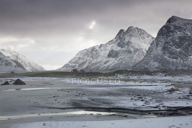 Vistas panorámicas montañas cubiertas de nieve Skagsanden Lofoten Noruega - foto de stock