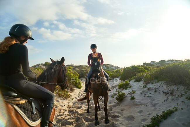 Jovens mulheres cavalgando na praia ensolarada — Fotografia de Stock