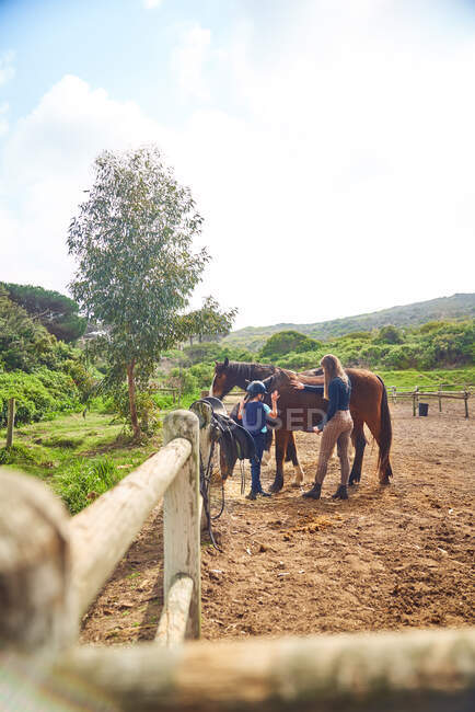 Instruktorin bringt Mädchen in sonniger Pferdekoppel das Reiten bei — Stockfoto