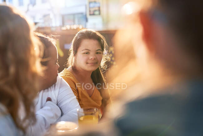 Portrait jeune femme souriante avec syndrome de Down dans un café avec des amis — Photo de stock