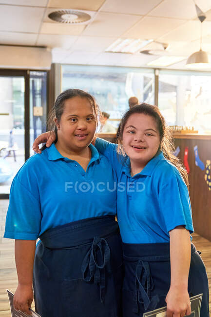 Portrait jeunes femmes confiantes atteintes du syndrome de Down travaillant dans un café — Photo de stock