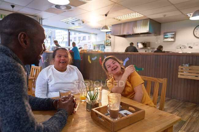 Happy young women friends with Down Syndrome laughing in cafe — Stock Photo