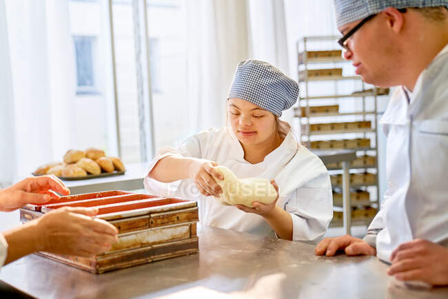 Young students with Down Syndrome baking bread in class — Stock Photo