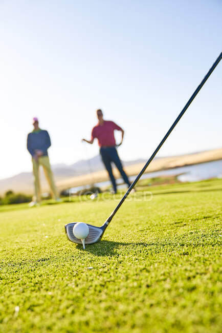 Golfer preparing to tee off on sunny golf course — Stock Photo