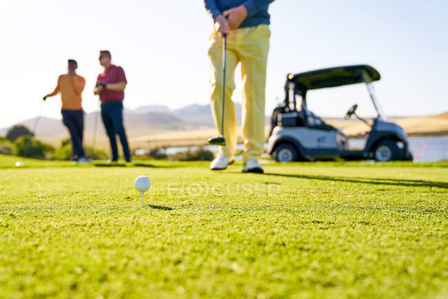 Чоловічий гольф готується до тріо на сонячному полі для гольфу — стокове фото