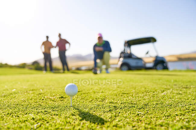 Pallina da golf su tee al tee box soleggiato — Foto stock