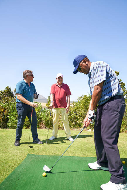 Golfista masculino praticando swing na gama de condução de golfe — Fotografia de Stock