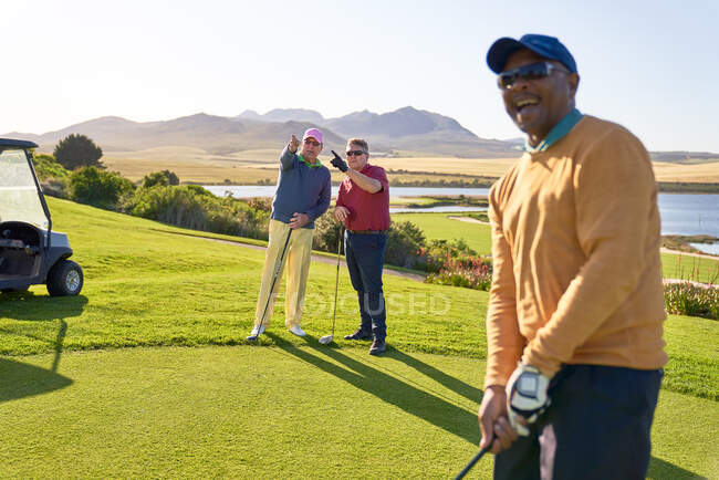 Männliche Golfer unterhalten sich auf sonnigem Golfplatz — Stockfoto