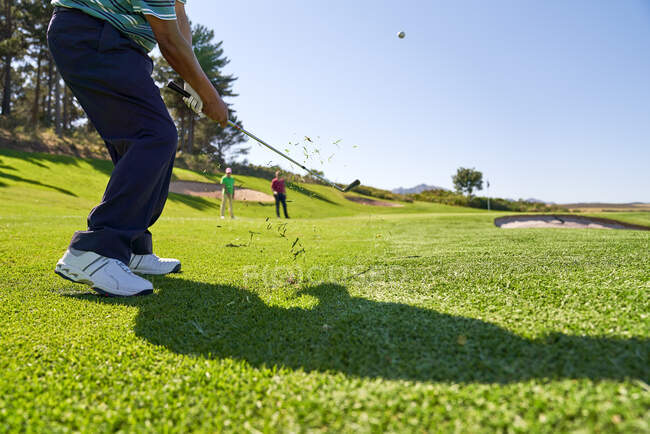 Homme golfeur prendre un coup sur le terrain de golf ensoleillé — Photo de stock