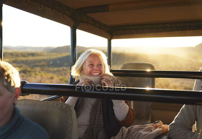 Happy senior woman on safari riding in off-road vehicle — Stock Photo