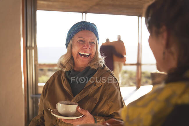 Felice anziane amiche che si godono il caffè e ridendo — Foto stock