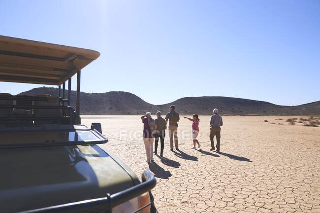 Safari tour grupo mirando soleado paisaje árido vista Sudáfrica - foto de stock