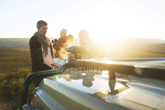 Safari grupo de turismo desfrutando de chá quente ao nascer do sol — Fotografia de Stock