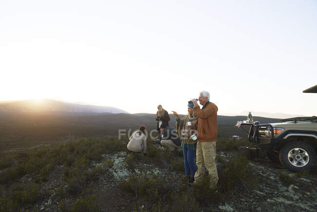 Safari-Reisegruppe trinkt Tee und genießt die Aussicht auf die Landschaft bei Sonnenaufgang — Stockfoto