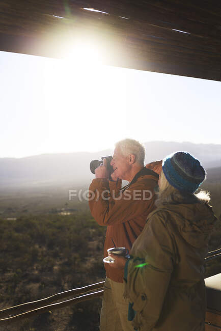 Seniorenpaar mit Kamera auf sonnigem Safari-Balkon — Stockfoto