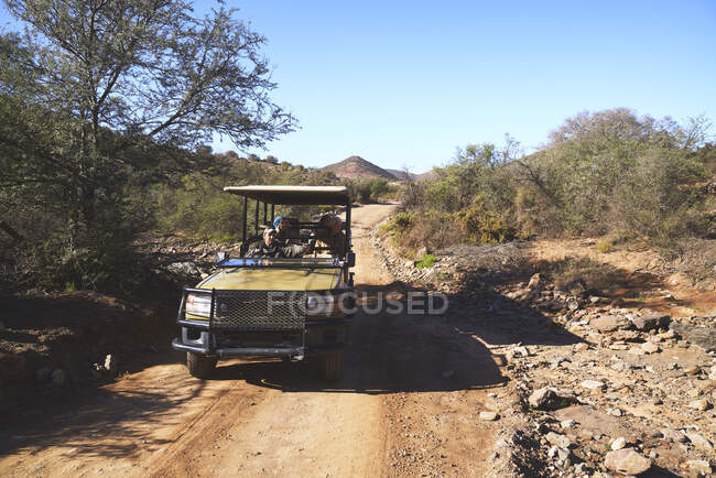 Тур Сафарі група подорожує бездоріжжжжям по сонячній багнистій дорозі — стокове фото