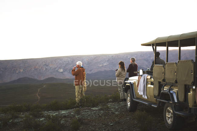 Safari tour en grupo disfrutando de la vista del paisaje Sudáfrica - foto de stock
