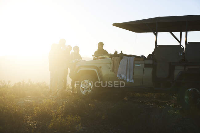 Safari grupo de viaje beber té fuera soleado vehículo todoterreno - foto de stock