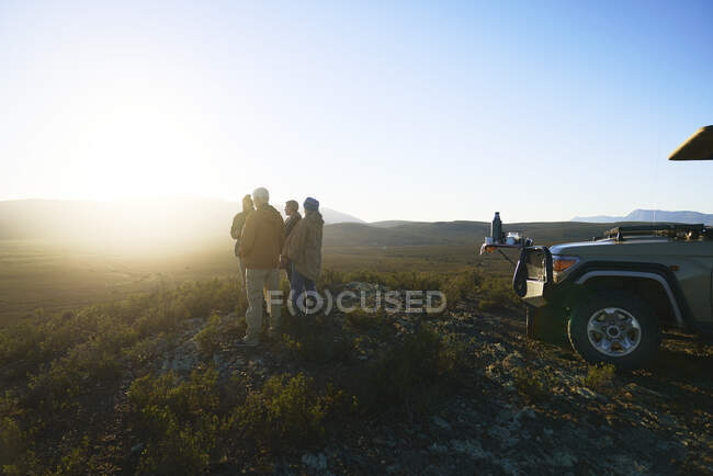 Safari tour grupo disfrutando de idílico amanecer desde la colina de Sudáfrica - foto de stock