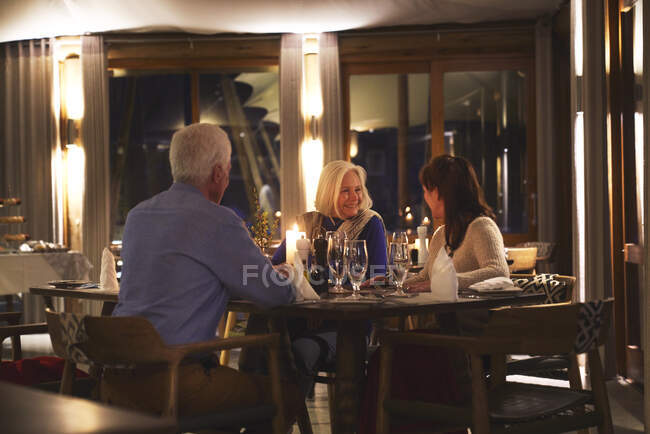 Senior friends enjoying dinner in restaurant — Stock Photo