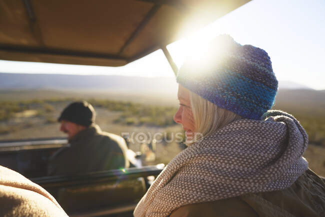 Happy senior woman riding in sunny safari off-road vehicle — Stock Photo