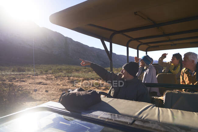 Safari guia turístico e grupo em veículo off-road ensolarado — Fotografia de Stock