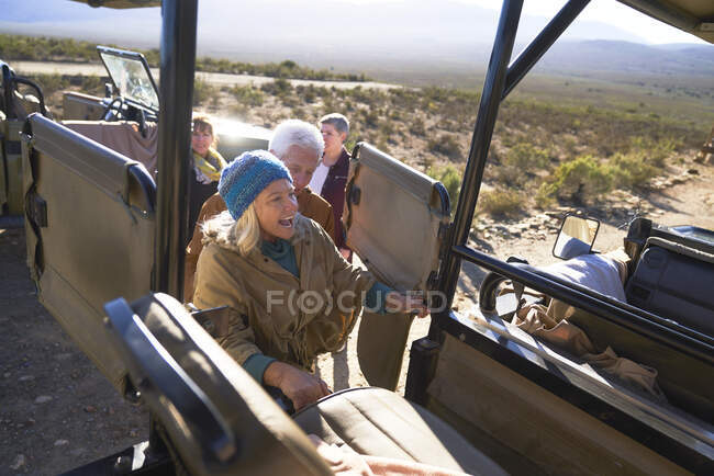 Mujer mayor feliz entrar en safari vehículo todoterreno - foto de stock