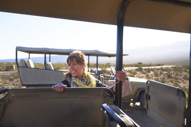 Mujer madura feliz entrar en safari vehículo todoterreno - foto de stock