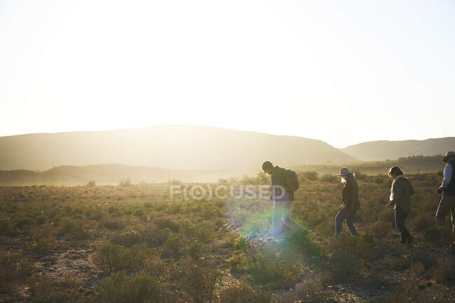 Safari-Reiseleiter führt Gruppe in sonnigem Grasland Südafrika — Stockfoto