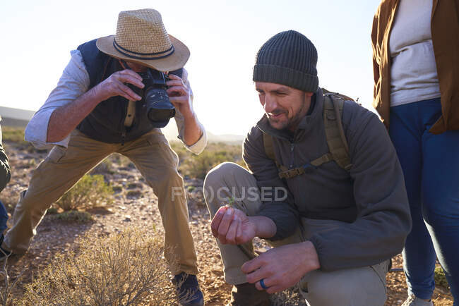 Safari tour guide explaining plants to tourist with camera — Stock Photo