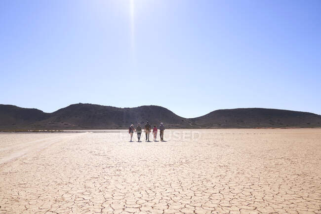 Safari tour grupo andando ao longo ensolarado terra rachada África do Sul — Fotografia de Stock