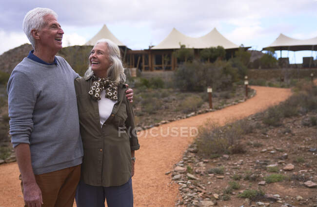 Glückliches Seniorenpaar auf Fußweg vor Safari-Lodge — Stockfoto