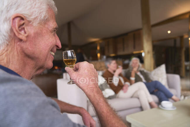 Sênior feliz bebendo cordial com amigos no hotel — Fotografia de Stock