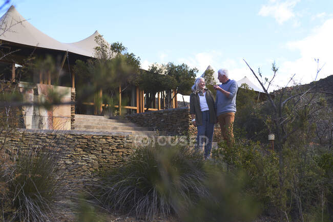 Senior couple standing outside safari lodge hotel — Stock Photo