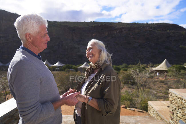 Happy senior couple on sunny safari lodge balcony South Africa — Stock Photo