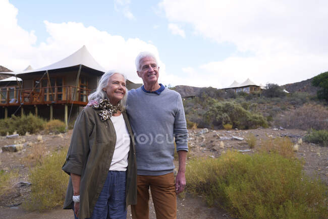 Feliz pareja de ancianos fuera de la cabaña safari lodge - foto de stock