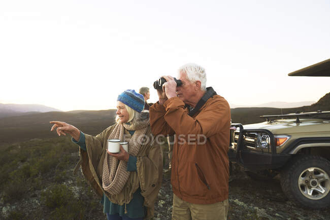 Senior couple with binoculars and tea on safari South Africa — Stock Photo