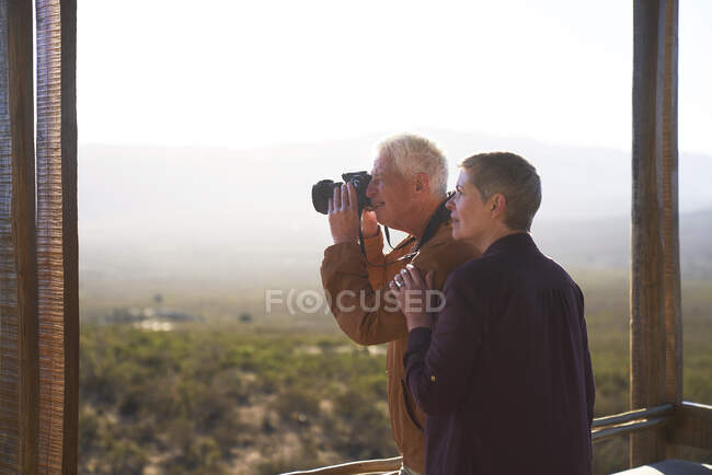 Seniorenpaar mit Kamera auf sonnigem Safari-Balkon — Stockfoto