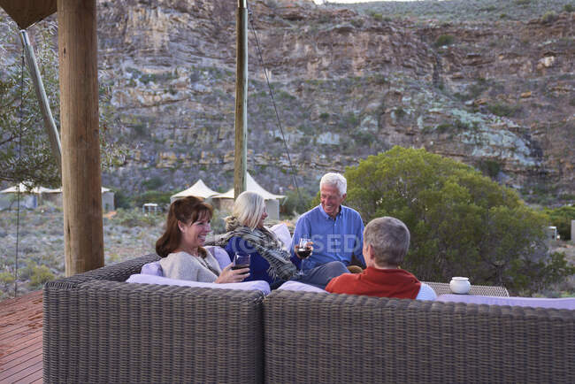 Amici anziani che si rilassano con il vino sul patio dell'hotel — Foto stock