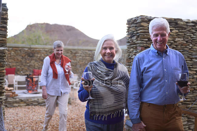 Портрет счастливая пожилая пара пьет вино в патио отеля — стоковое фото