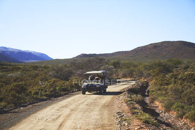 Safari véhicule tout-terrain sur route ensoleillée emote dirt road Afrique du Sud — Photo de stock