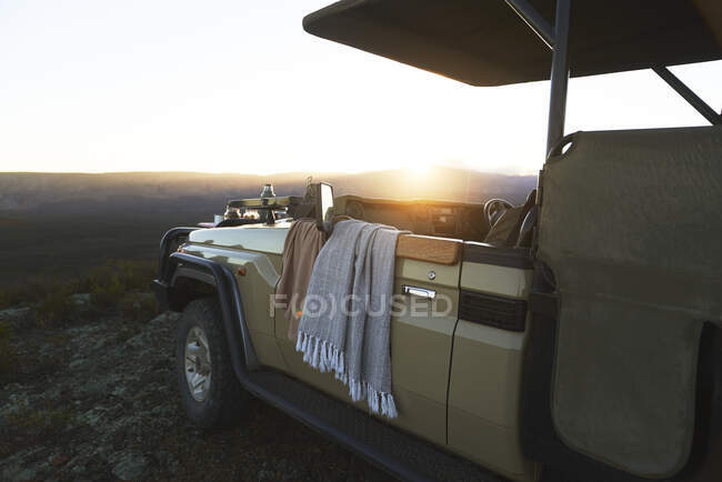 Salida del sol detrás de safari todoterreno vehículo Sudáfrica - foto de stock