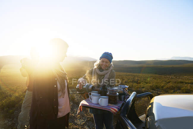 Mulher sênior feliz no safari derramando chá para amigo ao nascer do sol — Fotografia de Stock