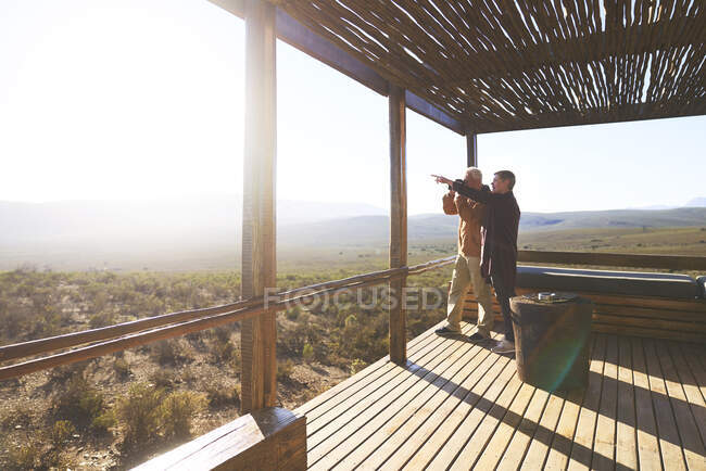 Seniorenpaar blickt vom Balkon der Safari-Lodge auf sonnigen Ausblick — Stockfoto