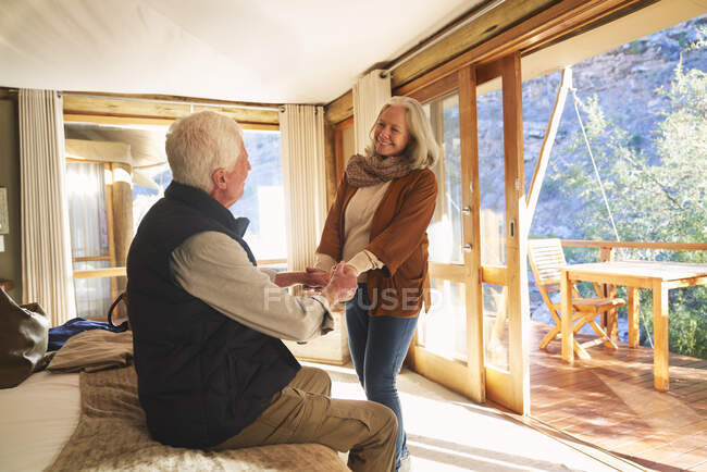 Glückliches Senioren-Paar hält Händchen im Safari-Lodge-Hotelzimmer — Stockfoto